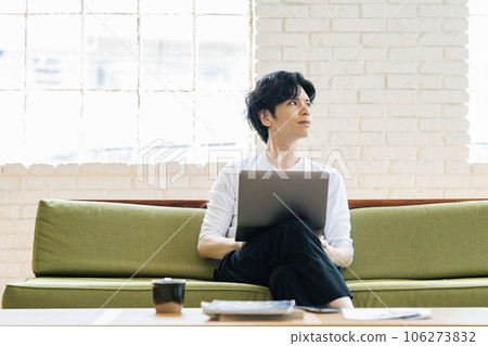 Man using a computer on a sofa at his stylish home 106273832