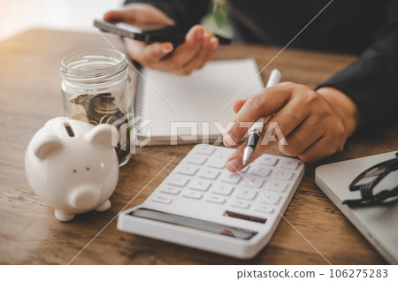 close up The business person is sitting on a calculator with a graph in the office of finance accounting concept 106275283
