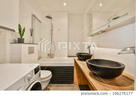 a modern bathroom with black and white tiles on the walls, wood counters and sink in the foreground a modern bathroom with black and white tiles on the walls, wood counters and sink in the foreground 106276177