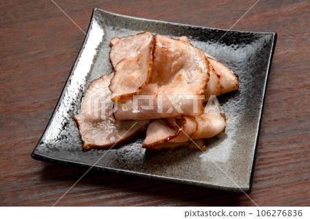 thinly sliced bacon fried in a frying pan 106276836