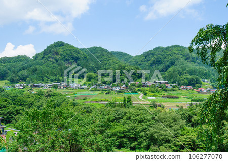 Rural village and blue sky seen from hill Rural village and blue sky seen from hill 106277070