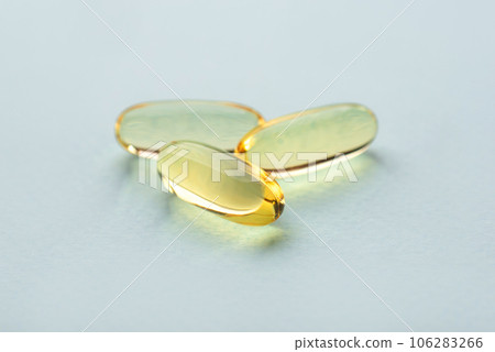 One omega 3 fish liver oil capsules on blue background. Close up, front view. 106283266