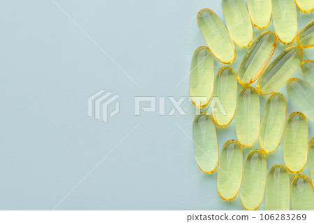 Omega 3 fish liver oil capsules on blue background. Top view, flat lay, copy space. 106283269