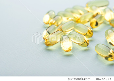Omega 3 fish liver oil capsules on blue background. Close up, front view. 106283273