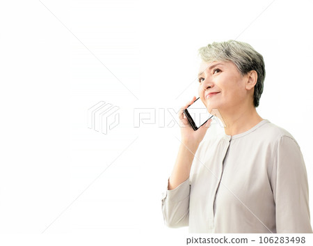 Listening to clients requirements. Beautiful senior woman talking on smart phone and smiling while standing against white background. Listening to clients requirements. Beautiful senior woman talking on smart phone and smiling while standing against white background. 106283498