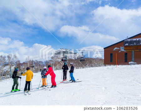 Skiers chatting while standing next to the ski lift stop (Niseko, Hokkaido) Skiers chatting while standing next to the ski lift stop (Niseko, Hokkaido) 106283526
