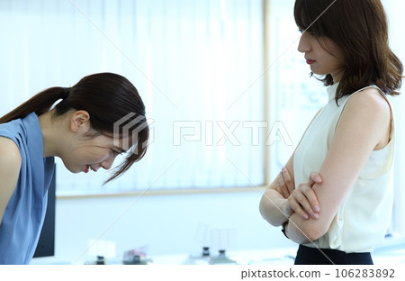 An image of a senior female employee giving strong guidance to a junior female employee 106283892