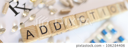 Word addiction, collected from wooden cubes with letters on doctor's prescription with many pills. Word addiction, collected from wooden cubes with letters on doctor's prescription with many pills. 106284406