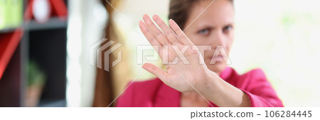 Serious female manager showing disagreement gesture while sitting in office. Serious female manager showing disagreement gesture while sitting in office. 106284445