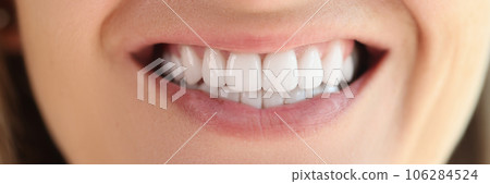 Close-up of female showing healthy smooth white teeth. 106284524