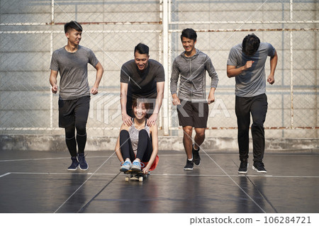 young asian adults men and woman having fun with skateboard outdoors 106284721