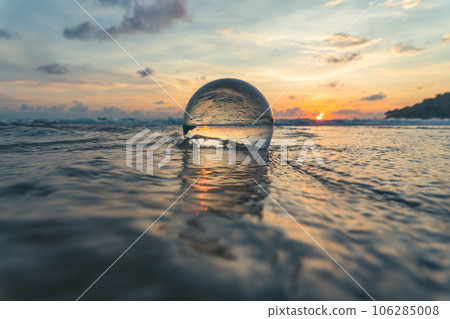 Magnificent sky above the crystal ball on the beach..The beautiful reflection of the sky above the crystal ball on the wet sand beach..Unique and creative travel and nature idea 106285008
