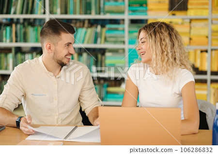 Portrait of boy and girl study in public library. Female using laptop and boy write something in notebook Portrait of boy and girl study in public library. Female using laptop and boy write something in notebook 106286832