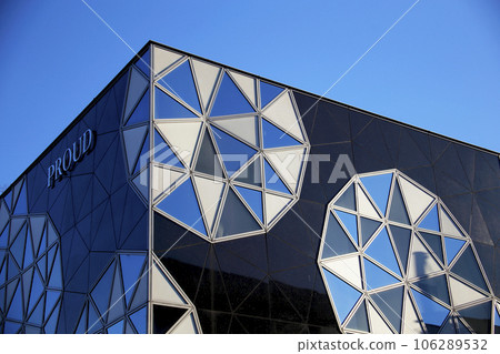 A building with a strange exterior that shines in the blue sky 106289532