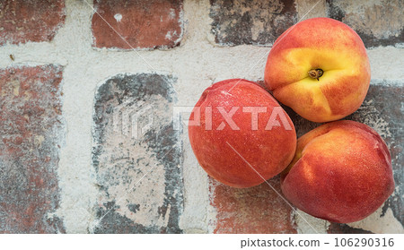 Peaches, layout on a brick rustic background. Top view of juicy ripe fruits, idea for a banner or mockup for advertising fresh fruits from a farm Peaches, layout on a brick rustic background. Top view of juicy ripe fruits, idea for a banner or mockup for advertising fresh fruits from a farm 106290316