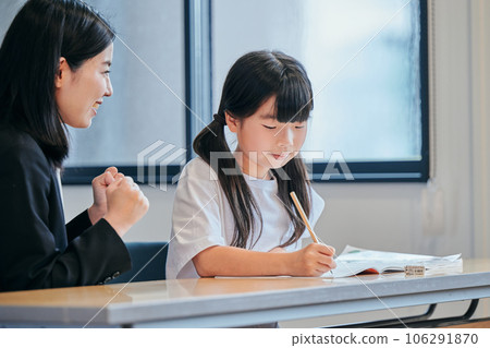 Elementary school girl encouraged by teacher at cram school Elementary school girl encouraged by teacher at cram school 106291870