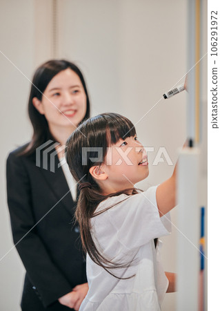 Elementary school girl writing answers on the whiteboard Elementary school girl writing answers on the whiteboard 106291972