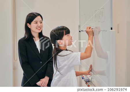Elementary school girl writing answers on the whiteboard 106291974