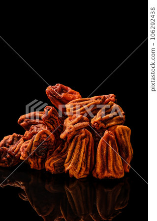Sun-dried persimmons on a black mirror table, close-up, selective focus on fruits. Vertical frame. Traditional Japanese dessert of dried persimmon 106292438