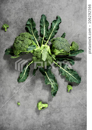 Broccoli inflorescences on laid out on a gray background, top view. Healthy vegetable products, food delivery from farms Broccoli inflorescences on laid out on a gray background, top view. Healthy vegetable products, food delivery from farms 106292566