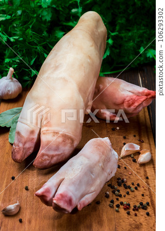 Jelly making kit - raw pork legs, pork shanks, beef legs, garlic and spices on a rustic wooden background. Close-up. Ingredients for khash or jellied meat 106293302