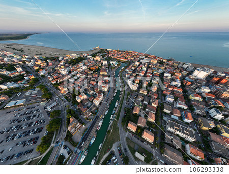 Aerial shot of a Caorle, the Resort sea beach city near to Venice. Fisherman boats in lagoon at sunset time 106293338