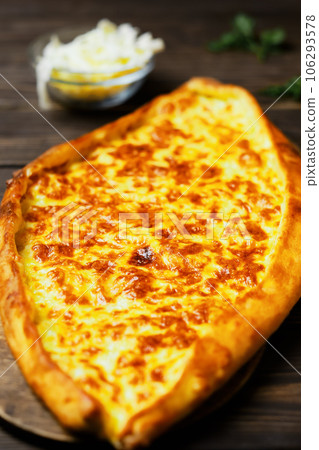 Turkish flatbread (pide) with cheese. Kasarli pide on the dark wooden table. Close up. Traditional turkish pizza 106293578