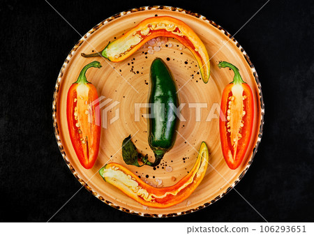 Spicy Mexican jalapeno peppers - Spanish tapas on a ceramic plate, black stone background. Selective focus, flat top view, food and drink still life concept Spicy Mexican jalapeno peppers - Spanish tapas on a ceramic plate, black stone background. Selective focus, flat top view, food and drink still life concept 106293651