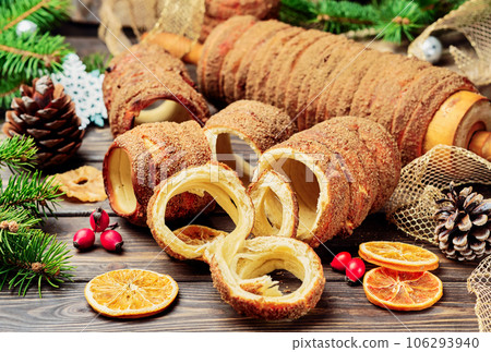 Trdelnik is a baked delicacy on a spit and charcoal dough with sugar, cinnamon and vanilla. Christmas sweets, street food. Czech and Moravian cuisine. 106293940