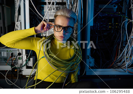 Portrait of tired overwhelmed female IT engineer at server room Portrait of tired overwhelmed female IT engineer at server room 106295488