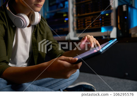 Teenager working at server, closeup view on hands using mobile tablet 106295576