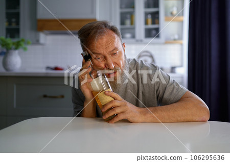 Portrait of lonely drunk man feeling depressed on home kitchen 106295636