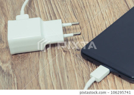 Black smartphone with charger. Various devices charging concept 106295741