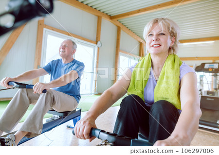 Senior couple in the gym on a rowing machine Senior couple in the gym on a rowing machine 106297006