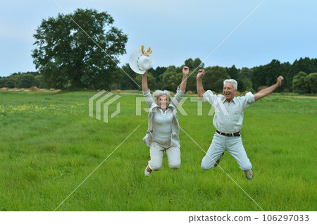 elderly couple jumps in summer in nature elderly couple jumps in summer in nature 106297033
