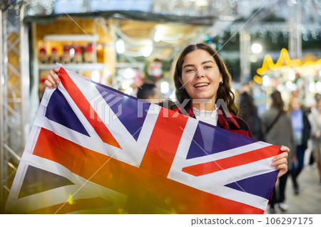 Happy girl with flag of United Kingdom at Christmas city market 106297175