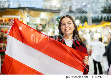 Cheerful girl with flag of Austria at city Christmas market 106297185