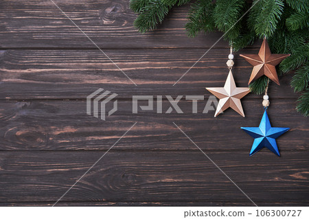Winter background with fir branches and Christmas decorations in form of star Winter background with fir branches and Christmas decorations in form of star 106300727