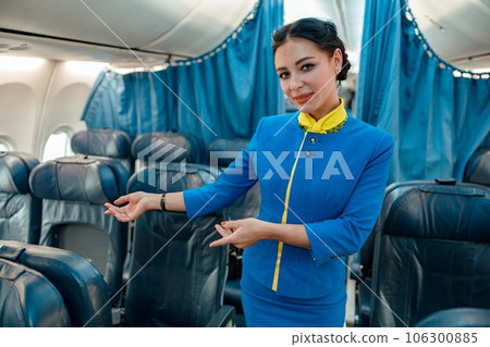Woman stewardess suggesting to take passenger seat in airplane 106300885
