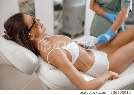 Cosmetology procedure with ipl machine from a professional cosmetologist in beauty salon 106300912