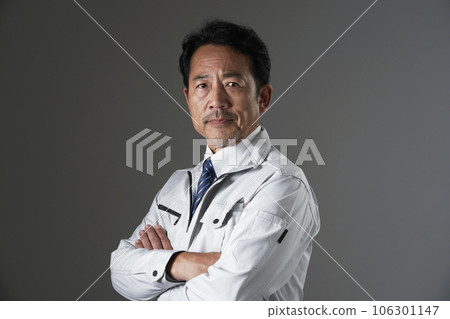 Portrait of a middle-aged worker, black background, looking at the camera 106301147