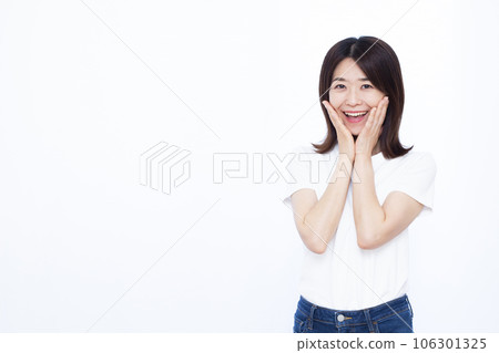 一個三十多歲的女人，在白色背景前微笑著感到驚訝 106301325