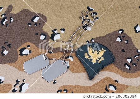 May 12, 2018. US ARMY Specialist rank patch and dog tags on desert camouflage uniform 106302384