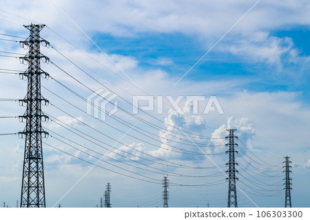 Electricity pylons and cumulonimbus clouds in the summer afternoon sky 106303300