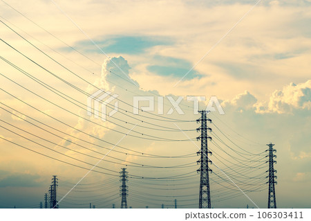 Transmission towers and cumulonimbus clouds in the summer afternoon and evening sky a-3 with warm colors Transmission towers and cumulonimbus clouds in the summer afternoon and evening sky a-3 with warm colors 106303411