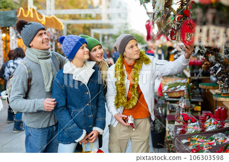Friendly family chooses Christmas souvenirs and toys 106303598