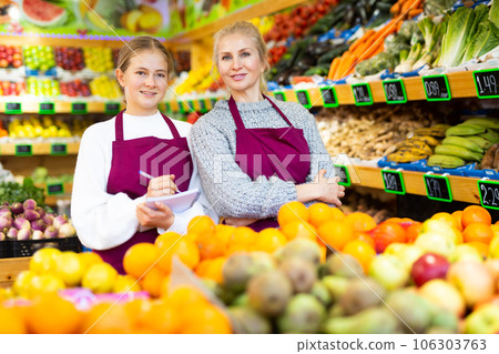 Girl helping her mother work as a salesman in a grocery store Girl helping her mother work as a salesman in a grocery store 106303763