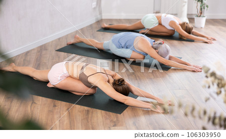 Young woman doing yoga in group in studio Young woman doing yoga in group in studio 106303950