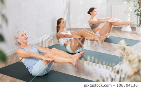 Elderly woman doing pilates in group in studio Elderly woman doing pilates in group in studio 106304136