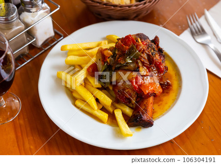 Baked pork knuckle with braised vegetables and fries 106304191